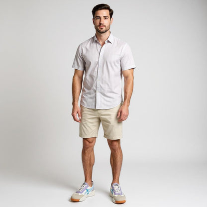 Mann trägt kurzärmliges, hell gestreiftes Hemd, beige Shorts und Onitsuka Tiger Sneaker aus Wildleder in Weiß, Beige, Flieder und Hellblau mit gezackter Sohle – stilvoller Sommerlook für Herren